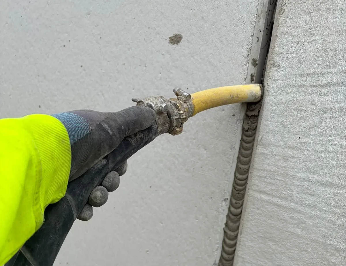 Vergussmörtel wird mit dem Injektionsschlauch in die Fuge zwischen zwei Betonfertigteilen eingebracht